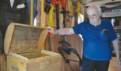 Auburn historian Jim Schneider is seen here with a wooden box that holds a great significance to the history of the community. It held all the food a number of English immigrants would eat over their two-week boat journey to Canada. Schneider has preserved the artifact for decades. (Mark Royall photo)
